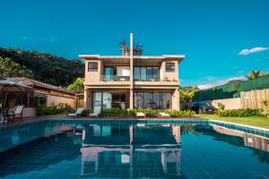 uma casa com piscina em frente a uma casa em Residencial Marina Del Sol em Pauba