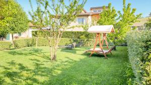 einen Garten mit Schaukel und Baum in der Unterkunft La Rosa Gialla Bio Apartments & rooms in Barolo