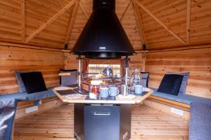 a room in a log cabin with a stove in it at Captain's Keep in Lymington