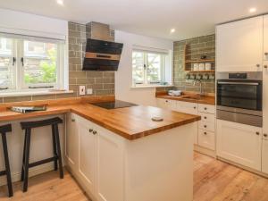 a kitchen with white cabinets and a wooden counter top at Wrens Nest in Kingsbridge