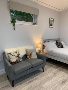 a living room with a couch and a bed at Cruachan Cabin in Oban