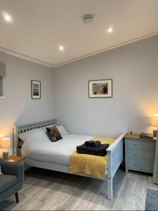 a bedroom with a bed and a desk and a chair at Cruachan Cabin in Oban