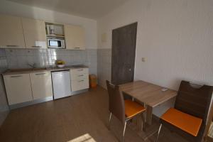 a small kitchen with a table and chairs in a room at Denjak Apartments in Kornić