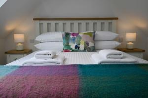 a bed with a colorful blanket and towels on it at The Barn in Fort William