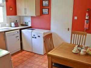 a kitchen with a white refrigerator and a table at Rowan Cottage-80119 in Catcleugh