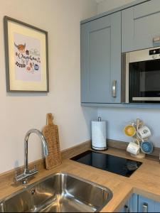a kitchen counter with a sink and a microwave at Lora Cabin in Oban