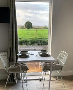 una mesa y sillas con vistas a un campo en Lora Cabin, en Oban