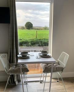 a table and chairs with a view of a field at Lora Cabin in Oban +2 photos