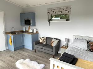 ein Schlafzimmer mit einem Bett und einer Küche und einer Couch in der Unterkunft Lora Cabin in Oban