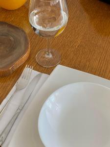 biały talerz i kieliszek wina na stole w obiekcie ZOGU Apartments - City Center w Prisztinie
