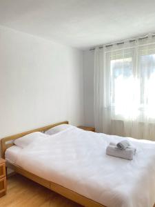białe łóżko z dwoma ręcznikami na górze w obiekcie ZOGU Apartments - City Center w Prisztinie