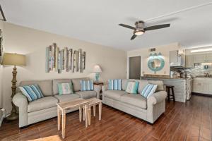 a living room with two couches and a kitchen at The Summit 731 in Panama City Beach