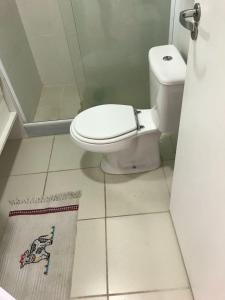 a bathroom with a toilet and a tile floor at Apartamento Reserva do Sahy - Condomínio Aldeia dos Reis in Mangaratiba