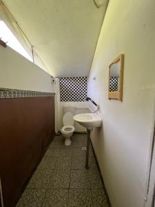 a small bathroom with a toilet and a sink at Mulu Village in Mulu