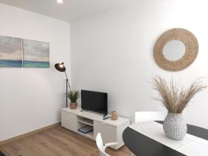 uma sala de estar branca com uma televisão e uma mesa em Aveiro Ria House em Aveiro
