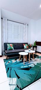 ein Wohnzimmer mit 2 Tischen und einem Sofa in der Unterkunft EVASION Bungalow Tropical Spa in Sarraméa