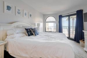 a bedroom with a large white bed and a window at Seascape 315 - Oceanfront Condo Overlooking Pool in Isle of Palms
