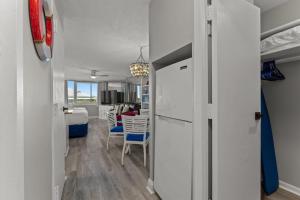 a kitchen with a refrigerator and a dining room at Top of The Gulf 306 in Panama City Beach