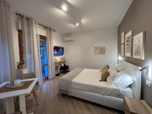 een witte slaapkamer met een bed, een tafel en een raam bij Mono Sirolo My house in Sirolo