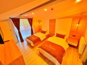 una camera da letto con due letti e una grande finestra di EYMEN APARTMENTS a Uzungöl