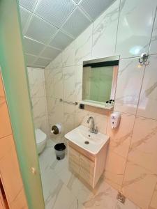 un bagno con lavandino, WC e specchio di EYMEN APARTMENTS a Uzungöl