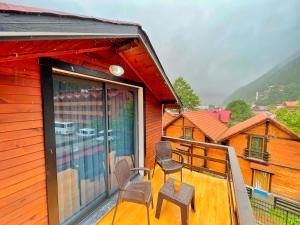 un balcone di una casa con 2 sedie di EYMEN APARTMENTS a Uzungöl