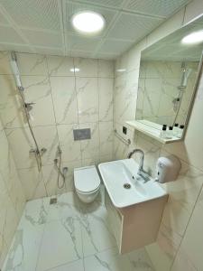 un bagno con lavandino, WC e specchio di EYMEN APARTMENTS a Uzungöl