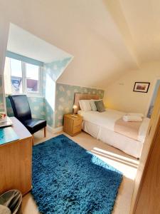 een slaapkamer met 2 bedden en een blauw tapijt bij Cleave Court Guest House in Llandudno
