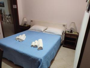 a bedroom with a bed with towels and slippers on it at Le Due Palme in Marsala