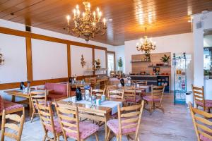 a dining room with tables and chairs and a chandelier at Mike‘s Mosel Lodge in Treis-Karden