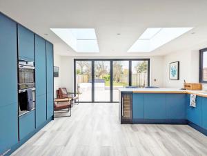 una cucina con armadi blu e piano di lavoro di Malthouse Cottage a West Wittering