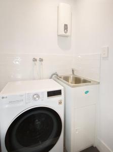 uma máquina de lavar roupa numa cozinha com um lavatório em Unit 3 - Manly Boutique Apartments em Brisbane