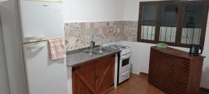 a small kitchen with a sink and a refrigerator at Hilda Roga in Posadas