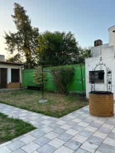 a fence with a green wall in a yard at Casa 9 de julio in Tandil