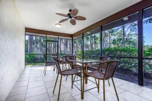 a dining room with chairs and a table and windows at Yellow Pine Duplex Close to Pool & Tennis in Sarasota