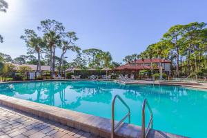 a swimming pool at a resort with palm trees at Yellow Pine Duplex Close to Pool & Tennis in Sarasota