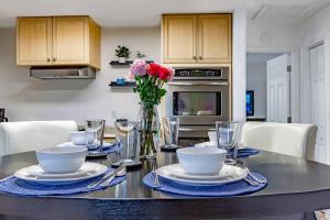 eine Küche mit einem Tisch mit Tellern und Blumen darauf in der Unterkunft Quaint Cottage in a South Sarasota Neighborhood in Sarasota