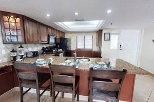 a kitchen with a large island with chairs around it at Siesta Sands Beach Resort Gulf View in Sarasota