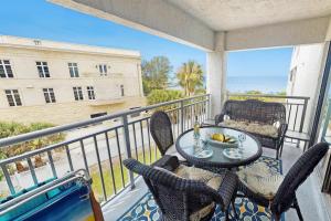a patio with a table and chairs on a balcony at Siesta Sands Beach Resort Gulf View in Sarasota +42 photos