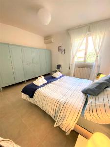 a bedroom with a large bed and a window at A 10 MINUTi DAL MARE in Grosseto