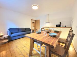 a living room with a wooden table and a blue couch at Bella Bela Apartments 23 in Bled