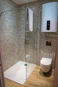 uma casa de banho com um WC e uma cabina de duche em vidro. em Studio cœur de ville sanary très cosy parking em Sanary-sur-Mer