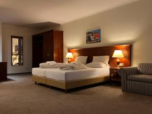 Hotel Hanseatischer Hof في لوبيك: غرفة نوم بسرير كبير وأريكة