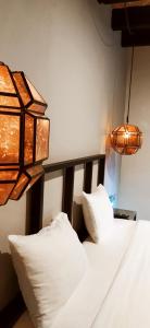 1 dormitorio con 2 almohadas blancas y lámpara en Hotel Naramu, en San Miguel de Allende