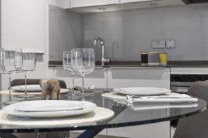 a table with plates and wine glasses on it in a kitchen at City View 1 Bedroom Flat in London