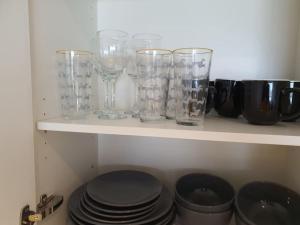 ein Regal mit Gläsern und Platten drauf in der Unterkunft City View 1 Bedroom Flat in London