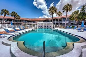 a large swimming pool with chairs and a building at Kingston Arms On Lido Key, 1BR in Sarasota