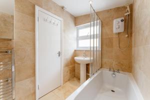 a bathroom with a bath tub and a sink at Mile End Double Rooms 27 Guest house in London