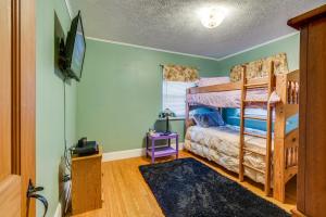 a bedroom with a bunk bed and a tv at Sodus Point Vacation Rental Steps to Lake Ontario in Sodus