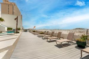 a row of chaise lounge chairs on a boardwalk at Best Western on the Beach in Gulf Shores